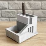 چیدمان اکسسوری بتنی شید روی میز اداری مدرن به همراه خودکار و کاغذ یادداشت